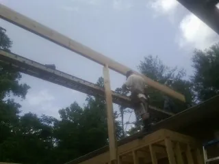Carpenter setting a ridge beam over a new addition frame — Ice Dam Removal by Roofing Brothers in New Hampton