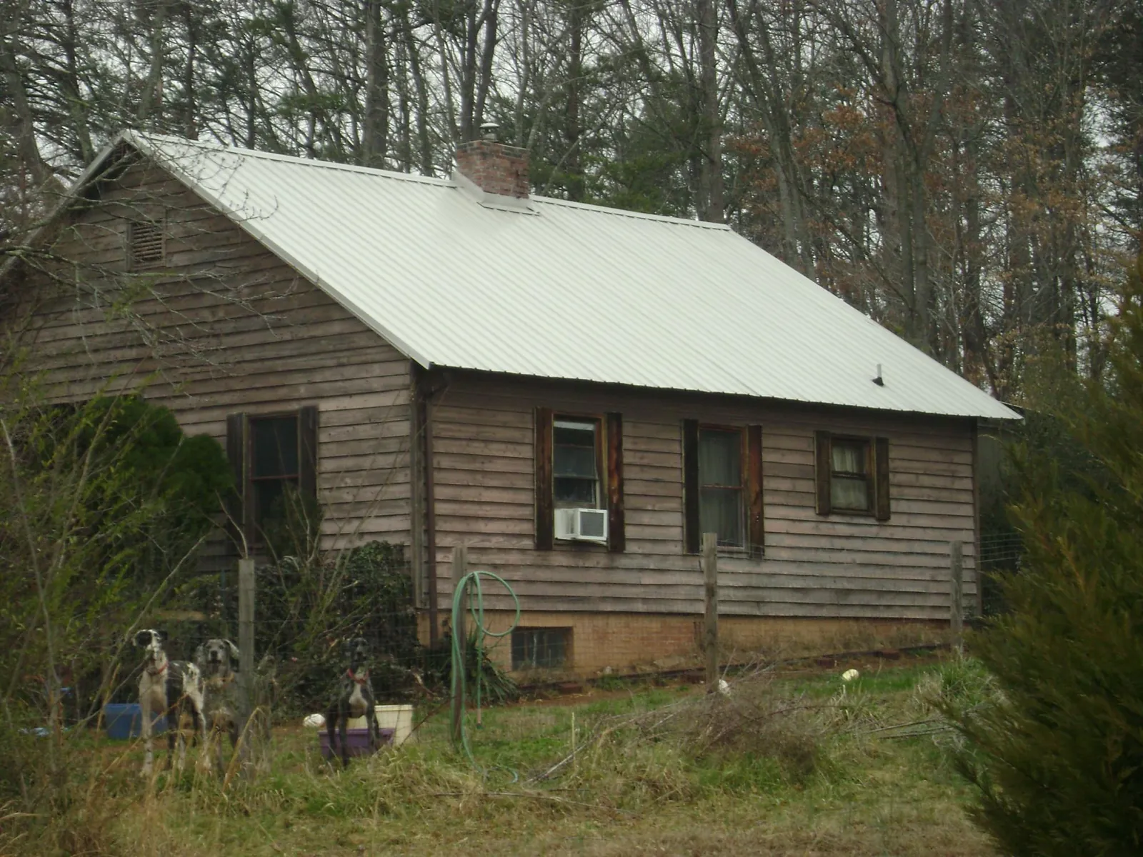 White metal roof on an old wood sided farmhouse, from a Metal Roof Installation job in New Hampton